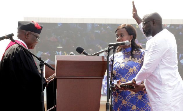 Liberia's new President George Weah raises his hand during the swearing-in ceremony at the Samuel Kanyon Doe Sports Complex in Monrovia